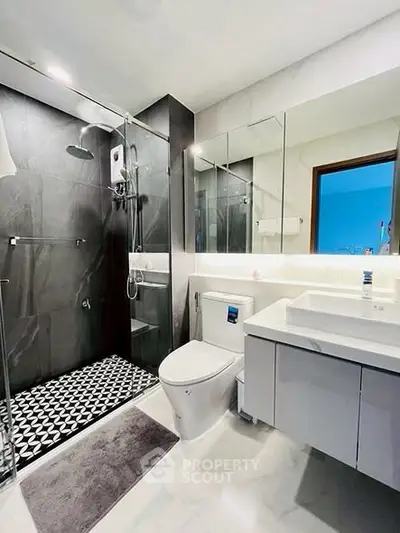 Modern bathroom with sleek design, featuring a glass shower and stylish vanity.