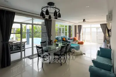 Spacious living room with pool view, modern decor, and abundant natural light.