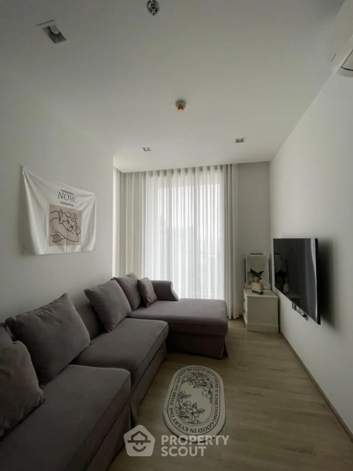 Modern living room with cozy gray sectional sofa and large TV, perfect for relaxation.