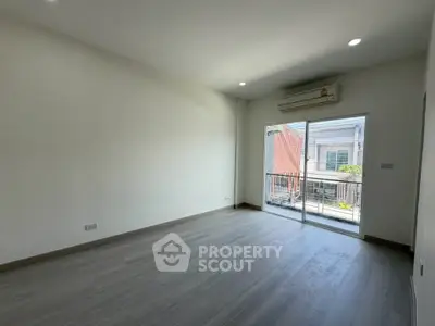 Spacious empty room with large window and air conditioning, perfect for customization.