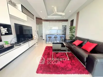 Modern living room with sleek design, vibrant red accents, and open kitchen layout.