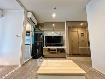 Modern living room with sleek design, featuring a large TV, air conditioning, and stylish wooden flooring.
