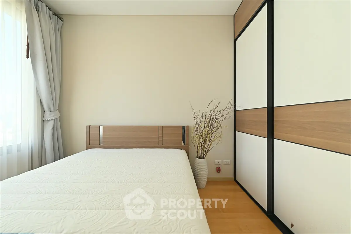 Modern minimalist bedroom with large window and stylish wardrobe