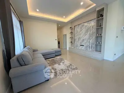 Spacious modern living room with elegant marble feature wall and cozy sectional sofa.