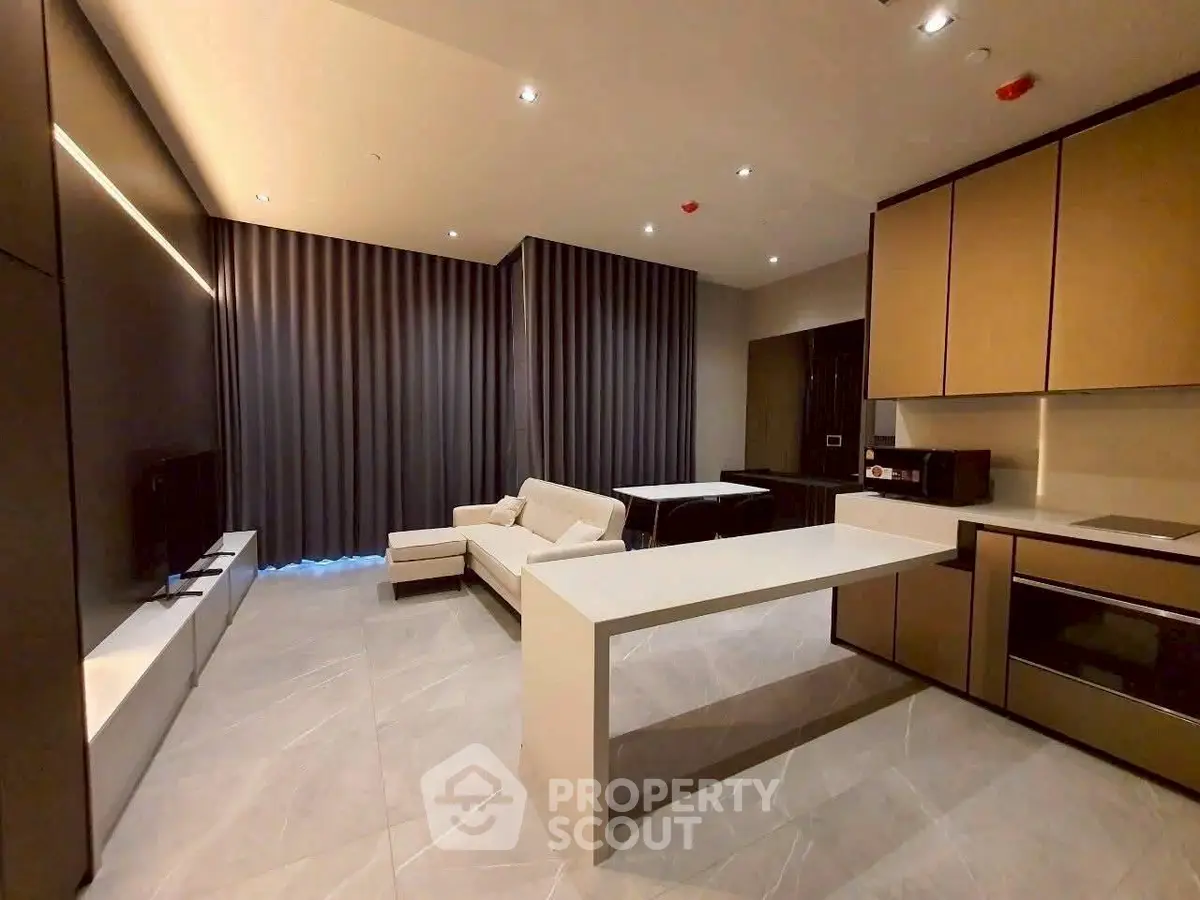 Modern living room with open kitchen, sleek design and cozy seating area