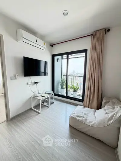 Modern living room with balcony view, featuring sleek decor and natural light.