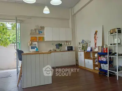 Charming kitchen with open layout and modern decor, featuring wooden flooring and ample natural light.