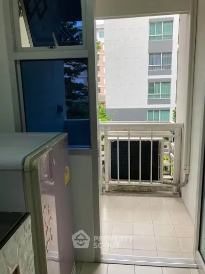 Compact balcony view from kitchen with modern appliances in urban apartment