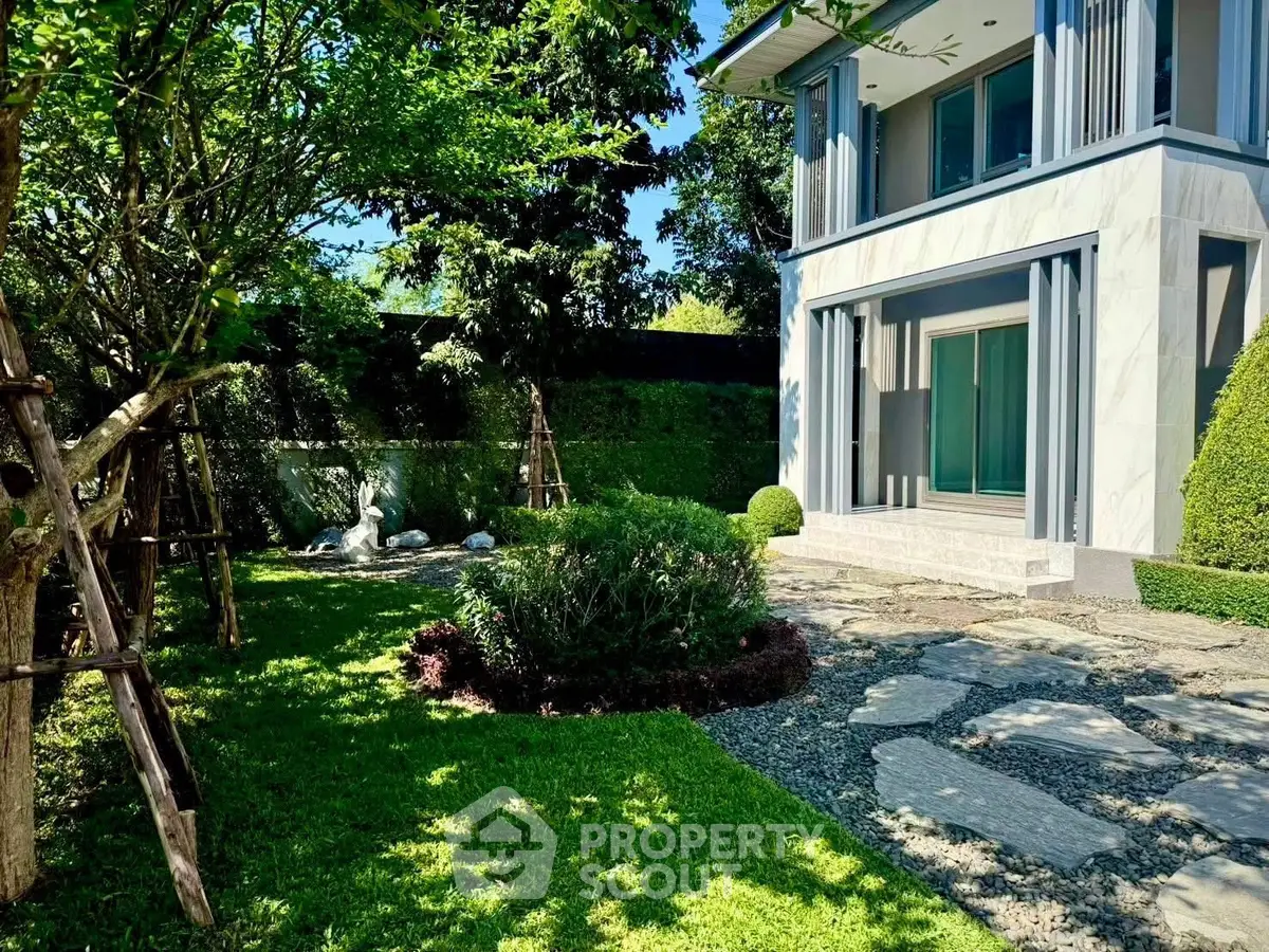Luxurious modern home with lush garden and elegant stone pathway, perfect for serene living.
