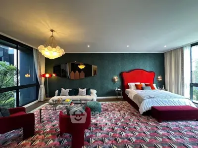 Luxurious bedroom with vibrant decor and large windows offering natural light