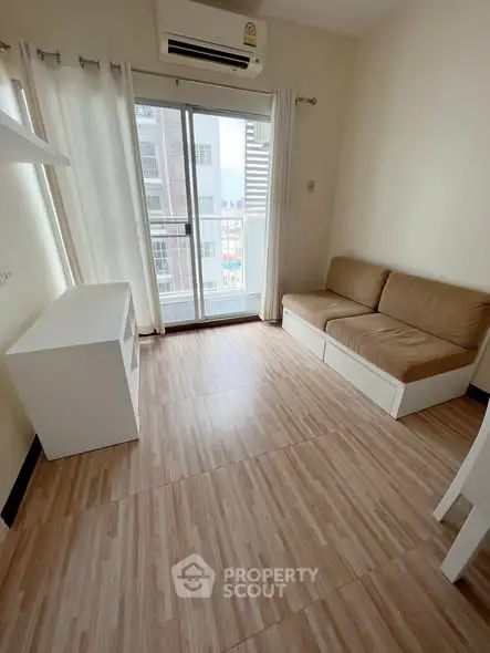 Cozy living room with wooden flooring and balcony access in modern apartment