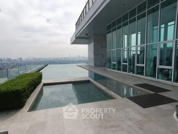 Luxurious rooftop pool with stunning city skyline view and modern glass architecture.