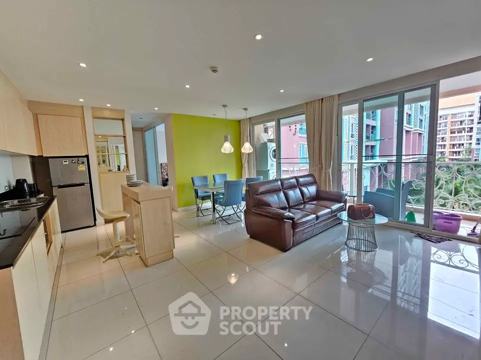 Spacious modern living room with open kitchen and balcony view