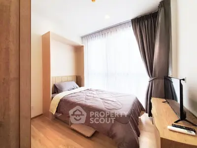 Cozy bedroom with modern decor and large window for natural light.