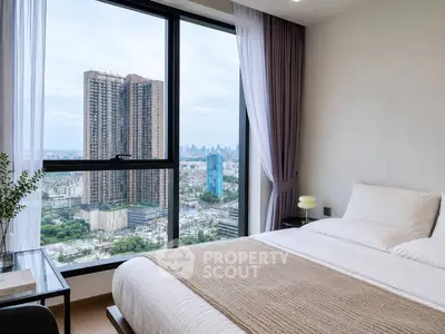 Luxurious bedroom with stunning city view from large window, modern decor and cozy ambiance.