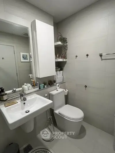Modern bathroom with sleek fixtures and minimalist design, featuring a wall-mounted sink and toilet.