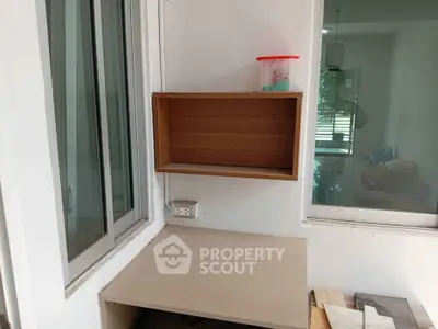 Compact study nook with built-in shelf and window view, ideal for small spaces.