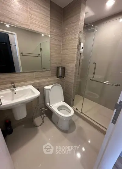 Modern bathroom with sleek shower and elegant fixtures in contemporary apartment.
