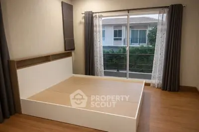 Spacious bedroom with large window and balcony view in modern home