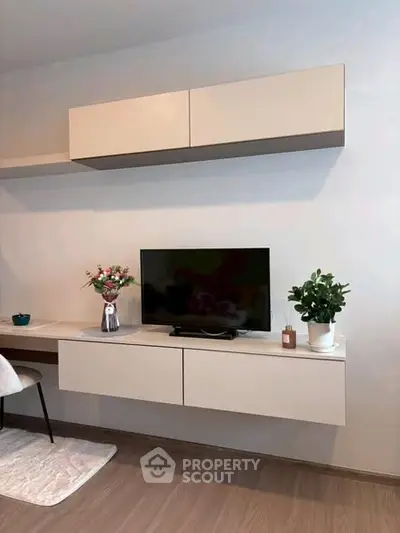 Modern living room with sleek wall-mounted TV and stylish storage cabinets.