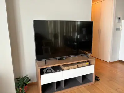 Modern living room with sleek TV setup and wooden flooring