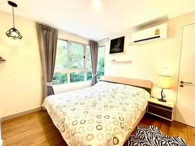 Cozy bedroom with large window and modern decor, featuring a comfortable bed and stylish lighting.