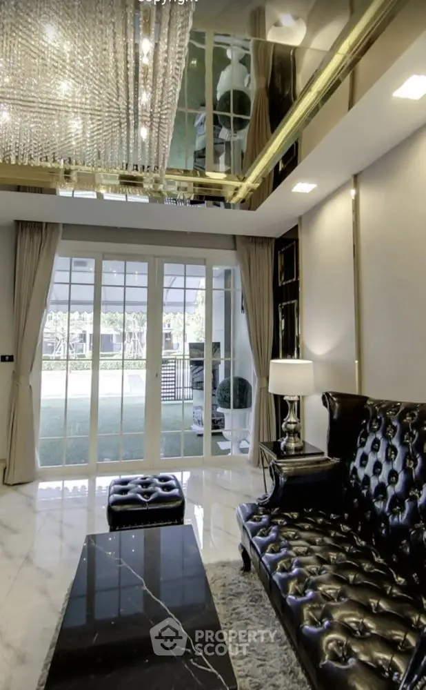 Luxurious living room with elegant black leather sofa and stunning chandelier