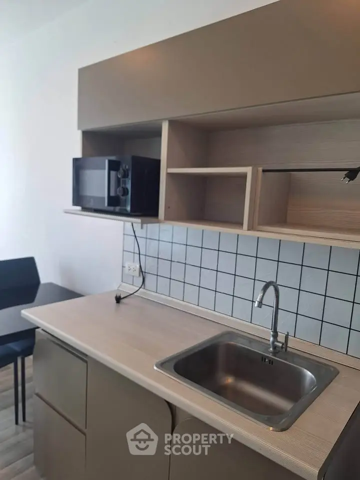 Modern kitchen with sleek cabinetry and built-in microwave, perfect for urban living.