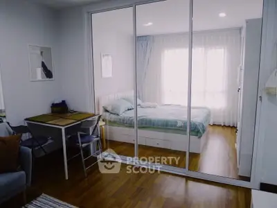 Modern bedroom with glass partition and cozy dining area in stylish apartment.