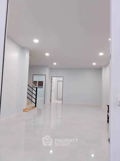 Spacious modern living room with sleek design and ample lighting.