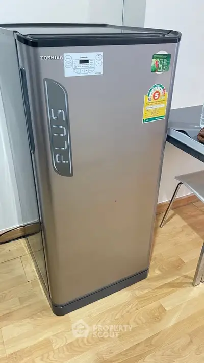 Modern Toshiba refrigerator in sleek kitchen setting with energy efficiency label.