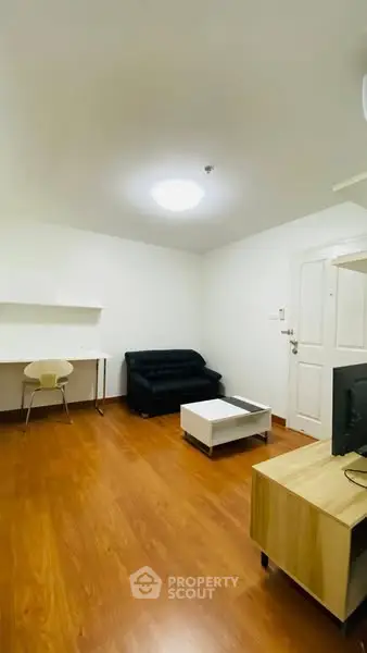 Spacious living room with modern furnishings and wooden flooring in a cozy apartment.