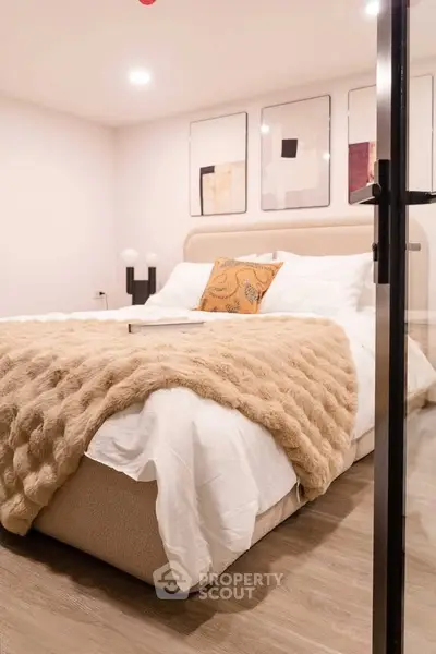 Cozy bedroom with modern decor and plush bedding in a stylish apartment.