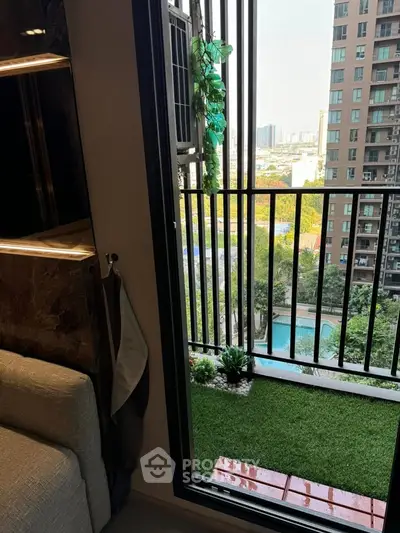Charming small balcony with artificial grass and city view, perfect for relaxation in urban living.