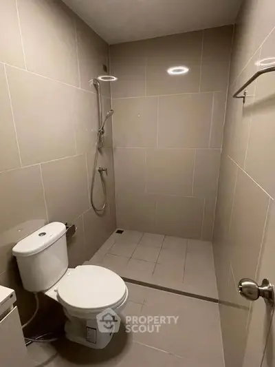 Modern minimalist bathroom with sleek tiles and walk-in shower design.