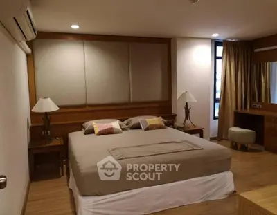 Spacious bedroom with elegant decor and natural lighting, featuring a comfortable bed and stylish furnishings.