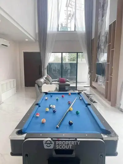 Luxurious living room with pool table and modern decor, perfect for entertainment and relaxation.