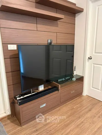 Modern living room with sleek wooden TV unit and mounted flat-screen TV