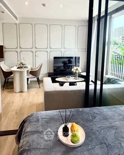 Modern living room with stylish decor and open layout, featuring a cozy dining area and large windows.