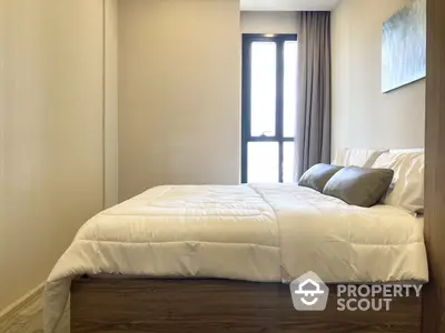 Cozy bedroom with a large comfortable bed, crisp white bedding, and natural light streaming in from the balcony door, perfect for restful nights.