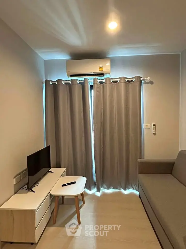 Cozy living room with modern furniture and air conditioning, perfect for relaxation.