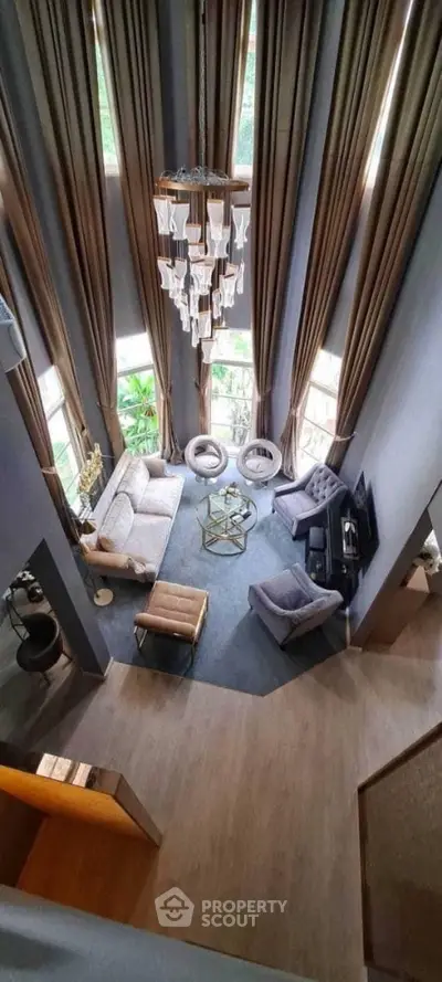Luxurious high-ceiling living room with elegant chandelier and modern decor