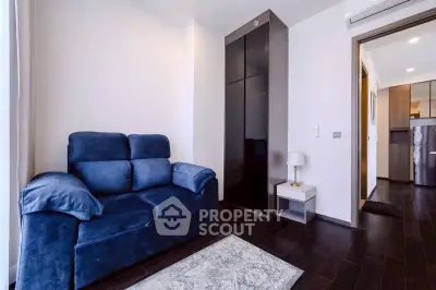 Modern living room with plush blue sofa and sleek dark wood flooring