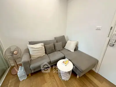 Cozy living room corner with gray sectional sofa and wooden flooring