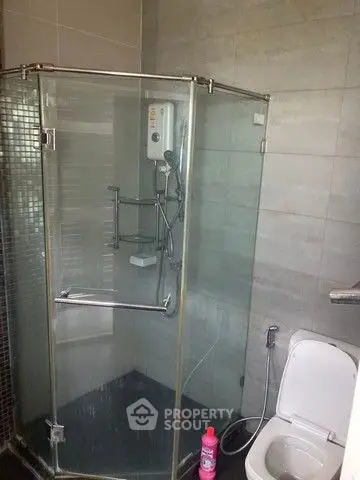 Modern bathroom with glass shower enclosure and sleek tile design.