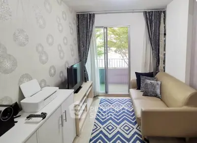 Cozy living room with modern decor, featuring a stylish sofa, TV, and balcony access.