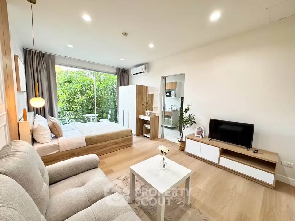 Modern studio apartment with cozy living area and garden view, featuring elegant decor and natural light.