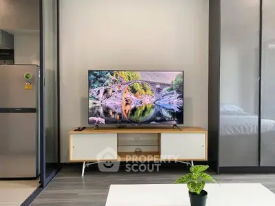 Modern living room with sleek TV setup and stylish decor in a contemporary apartment.