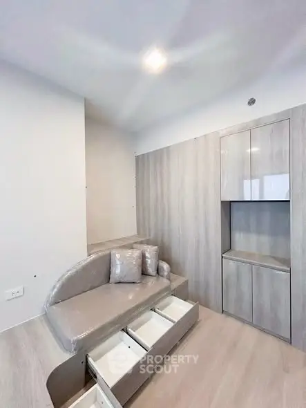 Modern minimalist living space with built-in storage and cozy seating area.