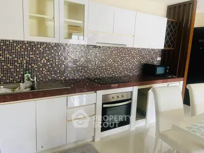 Modern kitchen with mosaic backsplash and sleek white cabinetry
